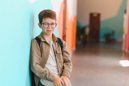 Sad schoolboy in school hallwayの写真素材