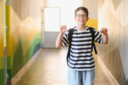 Smiling elementary school student walking through a school hallway after the school day, radiating...