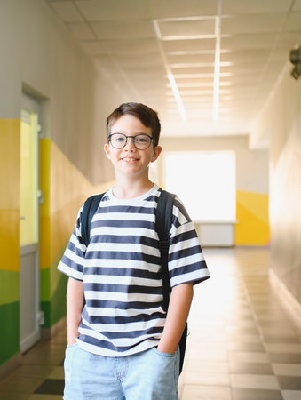Cheerful student standing confidently in a school hallway, embracing the excitement of learning and...