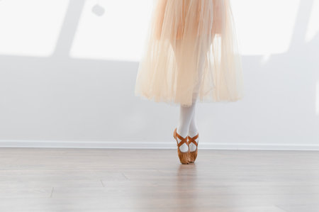 Young ballerina is practicing ballet in a dance school, wearing a tutu and pointe shoes, demonstrating grace and poiseの写真素材