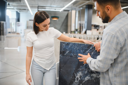 Young couple selecting blue marble look tiles in a home improvement store, planning a bathroom or kitchen renovationの写真素材