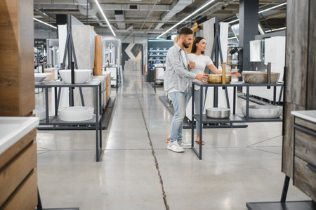 Young couple looking for bathroom sinks and faucets, shopping for home renovation and interior design in a retail showroomの写真素材