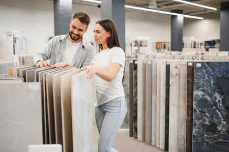 Young couple looking at sample tiles in a hardware store, planning for home renovation and interior design projectsの写真素材