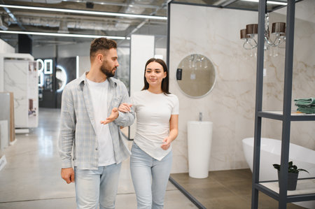 Young couple walking through a modern bathroom showroom, discussing home improvement options for their houseの写真素材