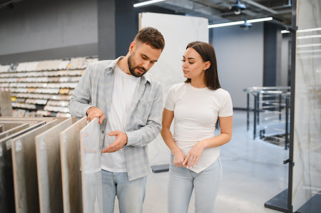 Young couple shopping for new flooring tiles, making renovation decisions in a modern hardware storeの写真素材