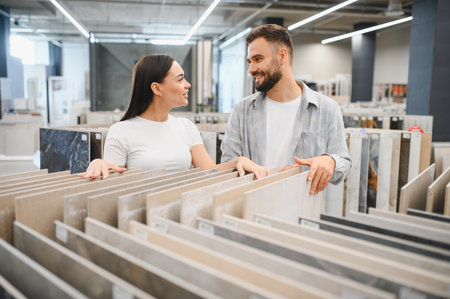 Young couple shopping for new floor or wall tiles, exploring options for their house improvement project, planning future designの写真素材