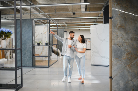 Couple choosing new ceramic tiles in a showroom, planning for home renovation and interior design projectsの写真素材