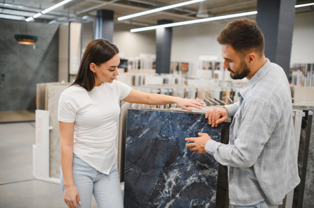 Young adult couple selecting marble effect tiles in a home renovation store for their flooring or bathroomの写真素材