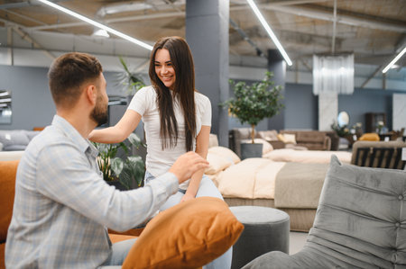 Smiling couple in a furniture store, deciding on home furnishings and buying items for their living spaceの写真素材