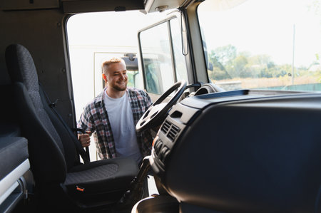 Young truck driver smiling as he opens the cab door and climbs into the semi truck, ready for a day...