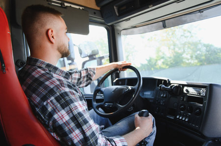 Young man driving heavy goods vehicle, navigating the road, focusing on transportation and logisticsの写真素材