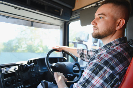 Young man driving a commercial truck, focusing on the road ahead. Representing logistics, delivery, and a career in transportationの写真素材