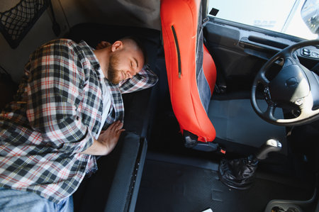 Man sleeping peacefully in a truck cabin, finding rest and recharging during a long journey on the...