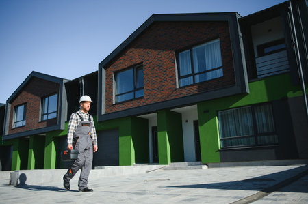 A plumber or builder is standing near a houseの写真素材
