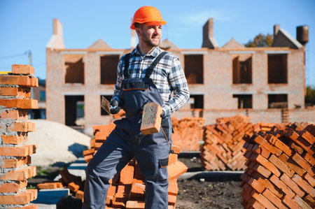 Construction worker in uniform and safety equipment have job on building.の写真素材