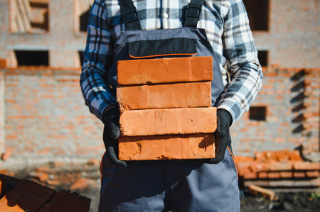 Construction worker in uniform and safety equipment have job on building.の写真素材