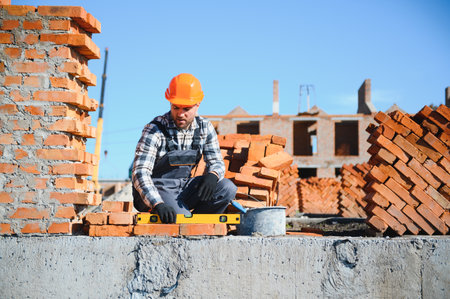 Construction worker in uniform and safety equipment have job on building.