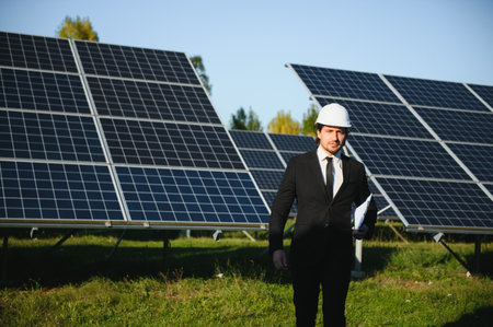 Portrait of a successful businessman or engineer inspecting the operation of solar panels. The concept of green energy.の写真素材