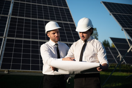 Portrait of engineers standing outside near solar panels.