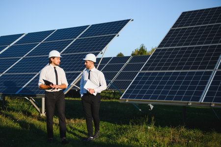 Portrait of engineers standing outside near solar panels.の写真素材