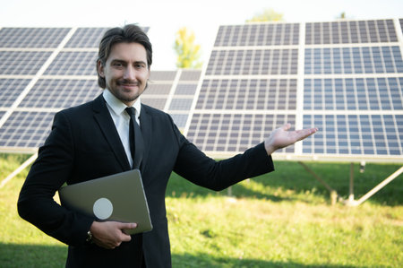Portrait of a successful businessman or engineer inspecting the operation of solar panels. The concept of green energy.の写真素材