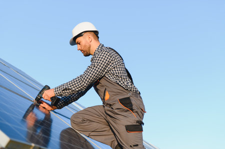 Man installer installing photovoltaic solar modules. Concept of alternative and renewable energy.の写真素材