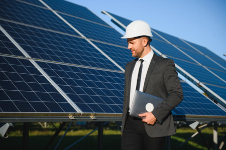 Businessman or engineer standing near solar panels.