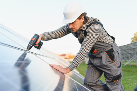 Man installer installing photovoltaic solar modules. Concept of alternative and renewable energy.の写真素材