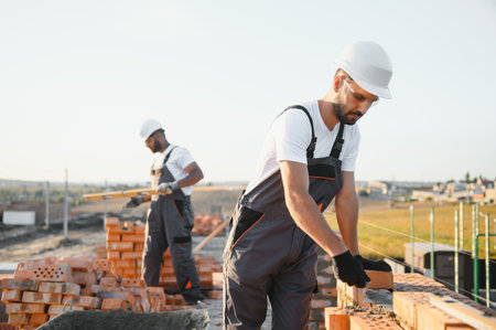 Man bricklayer installing bricks on construction site.の写真素材