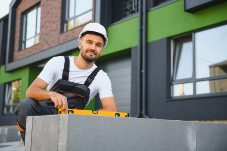 Builder on the background of new cottages. The concept of the construction of private cottages.の写真素材