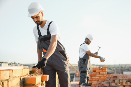 Man bricklayer installing bricks on construction site.の写真素材