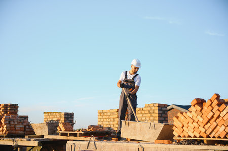 Construction worker in uniform and safety equipment have job on building.