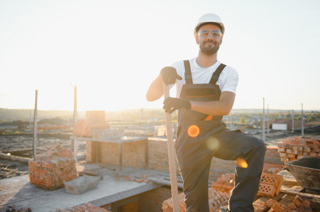 Installing brick wall. Construction worker in uniform and safety equipment have job on building.の写真素材