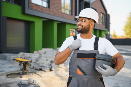 The concept of building family cottages outside the city. A young builder against the background of built townhouses.の写真素材