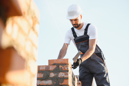 Construction worker in uniform and safety equipment have job on building.の写真素材