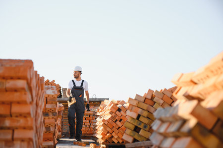 Construction worker man in work clothes and a construction helmet. Portrait of positive male builder...