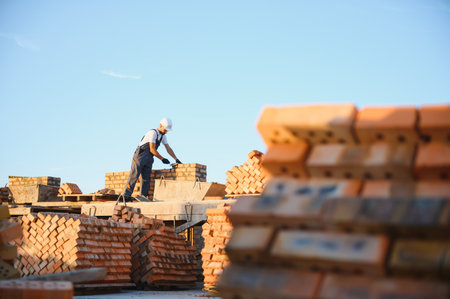 Construction worker in uniform and safety equipment have job on building.の写真素材