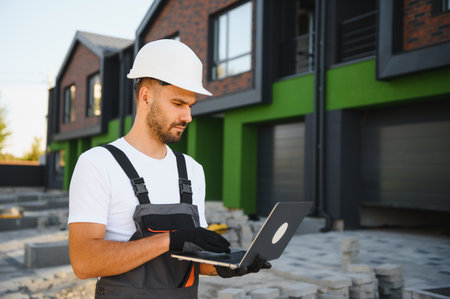 Joyful building site manager inspecting new cottage complex.の写真素材