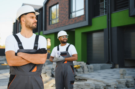Two builders on the background of new cottages. The work is done.の写真素材