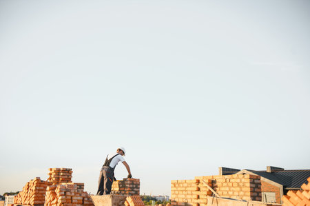 Man bricklayer installing bricks on construction site.の写真素材