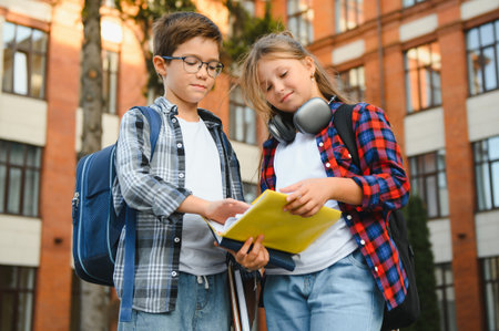 School friends, a boy and a girl spend time together near the school. Back to school.
