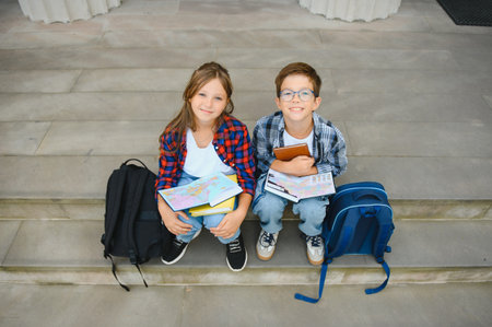 Group of school children reading books having an outdoor class.の写真素材