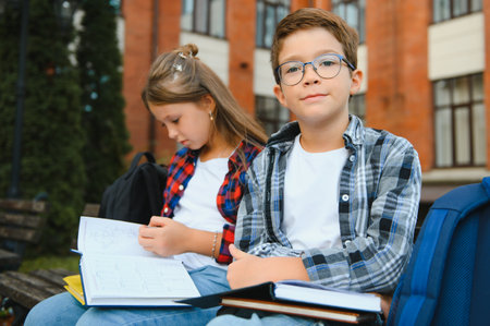 Happy schoolchildren near the school. A boy and a girl are primary school students. School friendship.の写真素材