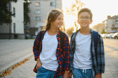 Happy children near the school. Friends boy and girl together in the school yard.