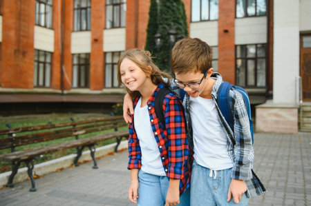 Happy children near the school. Friends boy and girl together in the school yard.の写真素材