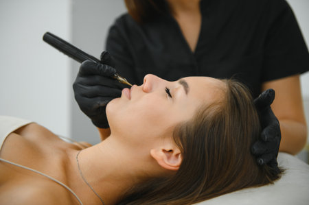 A cosmetologist applies permanent makeup to the eyebrows - eyebrow tattoo. eyebrow perm.の写真素材