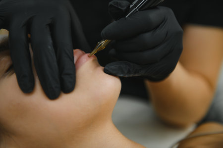 Young woman undergoing procedure of permanent lip makeup in tattoo salon.の写真素材