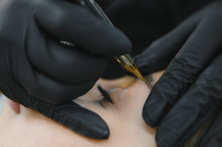 A cosmetologist applies permanent makeup to the eyebrows - eyebrow tattoo. eyebrow perm.の写真素材