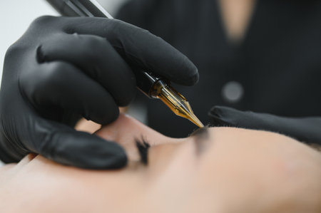 A cosmetologist applies permanent makeup to the eyebrows - eyebrow tattoo. eyebrow perm.の写真素材