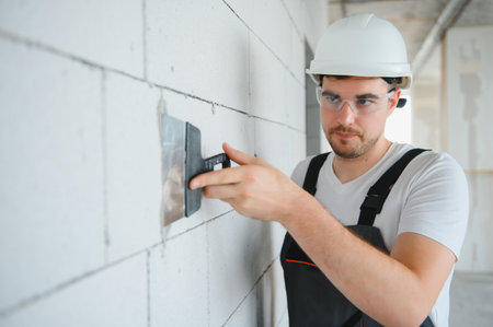 Construction site manager standing wearing helmet, thinking at construction site. Portrait of mixed race manual worker or architect.の写真素材